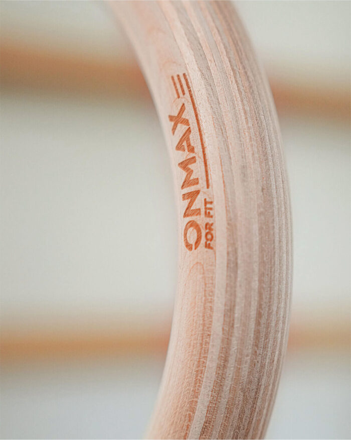 Zbliżenie na kółka gimnastyczne ONMAX z logo – sklejka bukowa